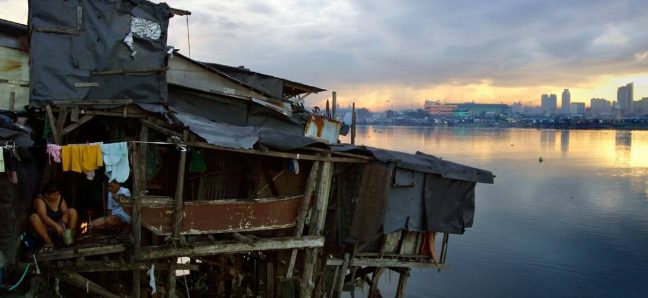 Manila: People in a waterside house raised on stilts in an informal settlement in Manila. Photo: Robin Hammond/Panos