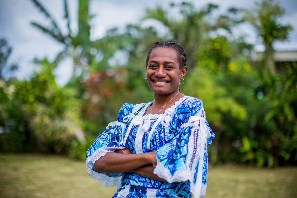 Jacquline stands in a garden in Vanuatu. Jacquline is a graduate of Youth Challenge Vanuatu's (YCV) Ready for Work program, which is run in partnership with Oxfam. She now works at the ombudsman office in Vanuatu.