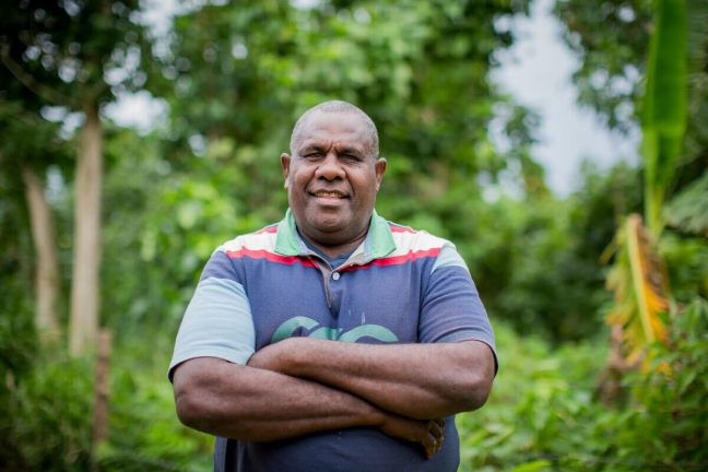 George stands with his arms crossed smiling at the camera. George joined the Vanuatu Society for People with Disabilities (VSPD) after an accident damaged his leg. He now advocates for the rights and inclusion of all people with disability.