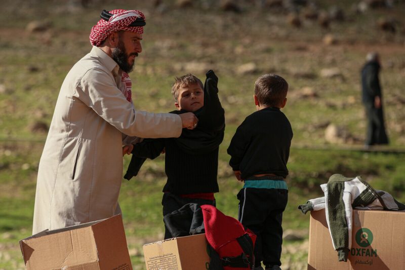 Syria: A man and his two young children from Aleppo's rural get winter supplies like blankets and coats from Oxfam to cope with the cold season. Photo: Islam Mardini/ Oxfam