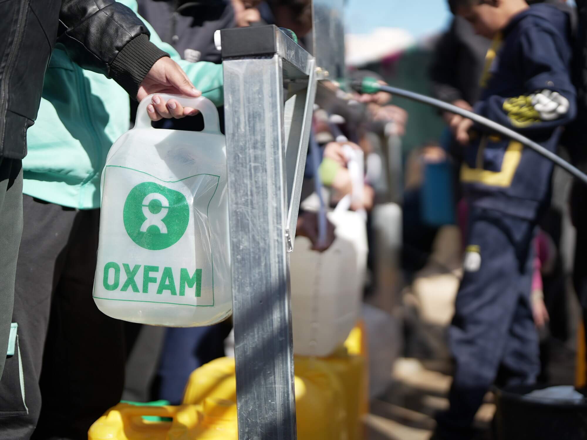 An Oxfam water container is filled with clean water in Gaza. Displaced People in Rafah in South Gaza to use the newly installed desalination units Oxfam and local partners provided. These units provide clean drinking water for free with no risk of contamination.