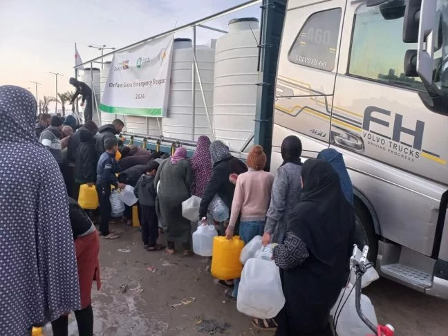 Gaza, Palestinian Territory, Occupied: Internally displaced people in Rafah filling desalinated water provided by Oxfam in partnership with the Youth Empowerment Center. Photo: Wassem Mushtaha/Oxfam