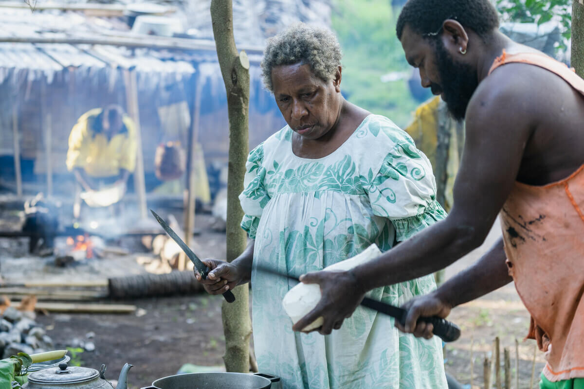 Molpoe, Vanuatu: Pamela, Antonnie and Roy prepare a local meal. Their home, Molpoe village in Vanuatu, was hit by a devastating landslide caused by torrential rain, which has become more frequent due to extreme weather. Oxfam acknowledges the support of the Australian Government through the Australian NGO Cooperation Program (ANCP). Photo:Ivan Utahenua/Oxfam