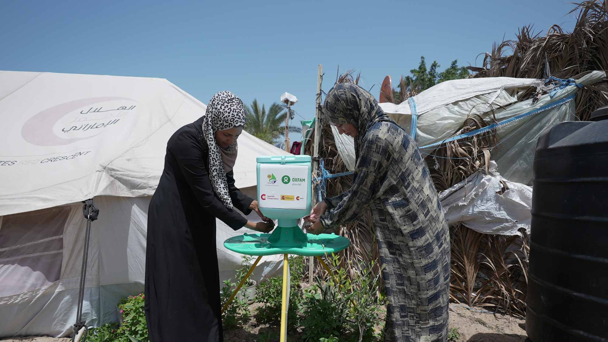 Palestinian Territory, Occupied: Some Oxfam community members are washing their hands at the hand washing stations in Al Mawasi Area. Alef Multimedia Company/Oxfam Gaza, Palestinian Territory, Occupied: Some Oxfam community members are washing their hands at the hand washing stations in Al Mawasi Area. Alef Multimedia Company/Oxfam