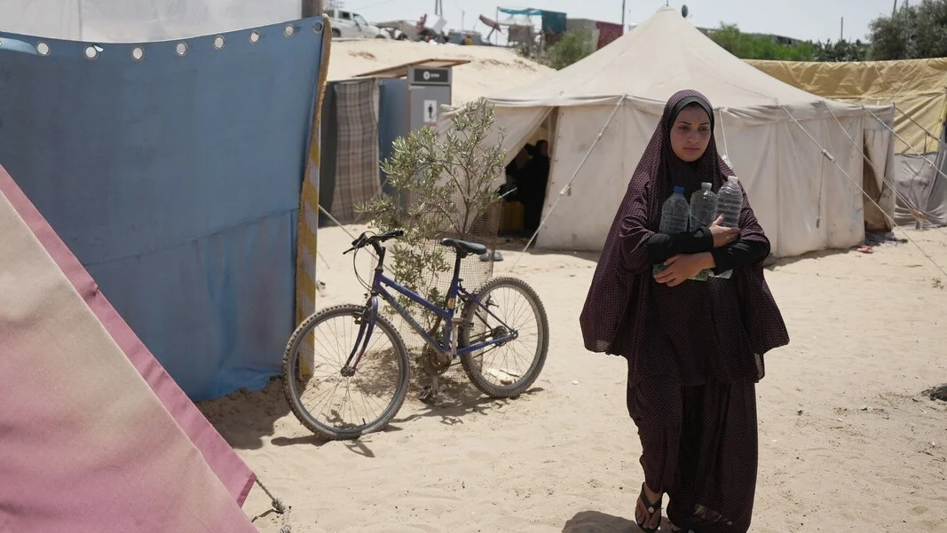 Palestinian Territory, Occupied: Duaa Abu Sabha holds water bottles while walking to her tent in the Al-Mawasi area in Khan Yunis Governorate. Photo: Alef Multimedia/Oxfam. Palestinian Territory, Occupied: Duaa Abu Sabha holds water bottles while walking to her tent in the Al-Mawasi area in Khan Yunis Governorate. Photo: Alef Multimedia/Oxfam.