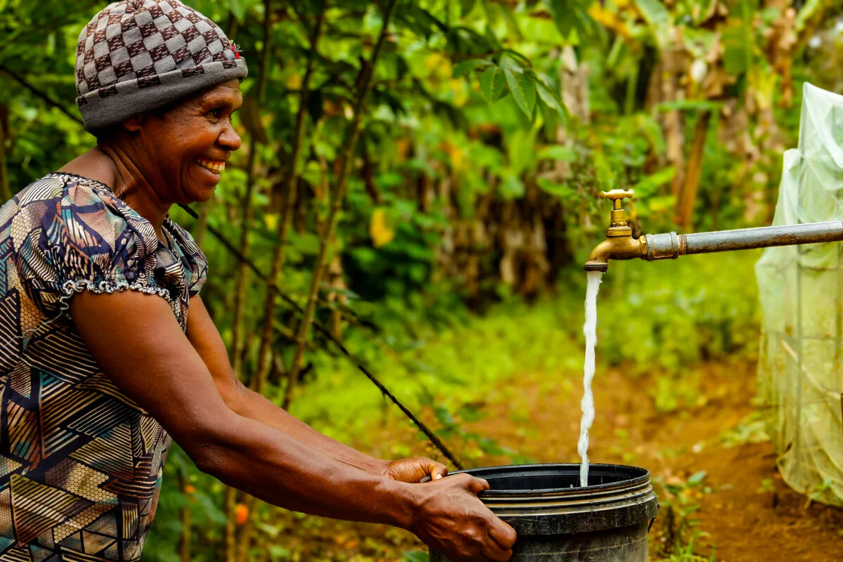 Papua New Guinea. Lavin of Nogorunte community in Papua New Guinea (PNG), shows off the new tap outside her home built by Oxfam's Kōtui Programme. Photo: Jeshua Hope / Oxfam Papua New Guinea. Lavin of Nogorunte community in Papua New Guinea (PNG), shows off the new tap outside her home built by Oxfam's Kōtui Programme. Photo: Jeshua Hope / Oxfam