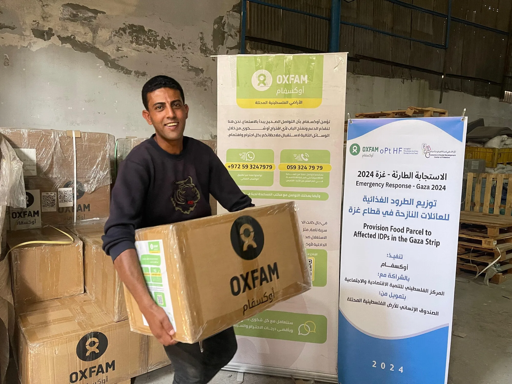 Palestinian Territory, Occupied: An Oxfam community member is receiving a food parcel for Oxfam in Gaza City. Photo: Jomana Elkhalili/Oxfam Palestinian Territory, Occupied: An Oxfam community member is receiving a food parcel for Oxfam in Gaza City. Photo: Jomana Elkhalili/Oxfam