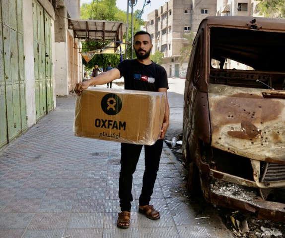 Palestinian Territory, Occupied: Raed Mansour is holding the Oxfam food parcel distributed among displaced people . He and his wife are challenged to make food for their three children who lost significant weighs during the Israel's war on Gaza. Photo: Alef Multimedia Company/ Oxfam