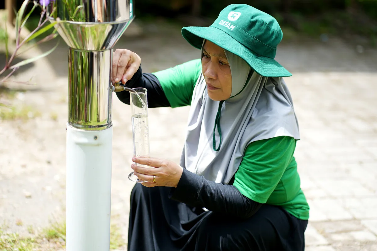 Lombok, Indonesia: Mariani operates an ombrometer and documents water levels in her village every day as part of her community's anticipatory action response. Photo: Aimee Han/Oxfam
