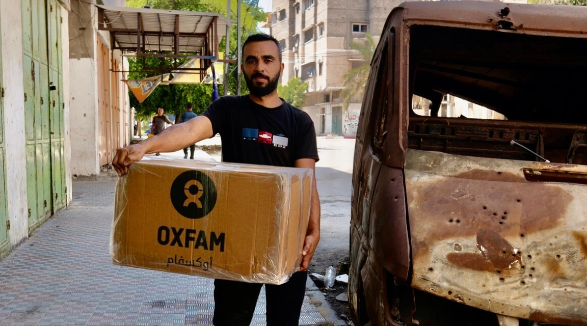 Palestinian Territory, Occupied: Raed Mansour is holding the Oxfam food parcel distributed among displaced people . He and his wife are challenged to make food for their three children who lost significant weighs during the Israel's war on Gaza. Photo: Alef Multimedia Company/ Oxfam