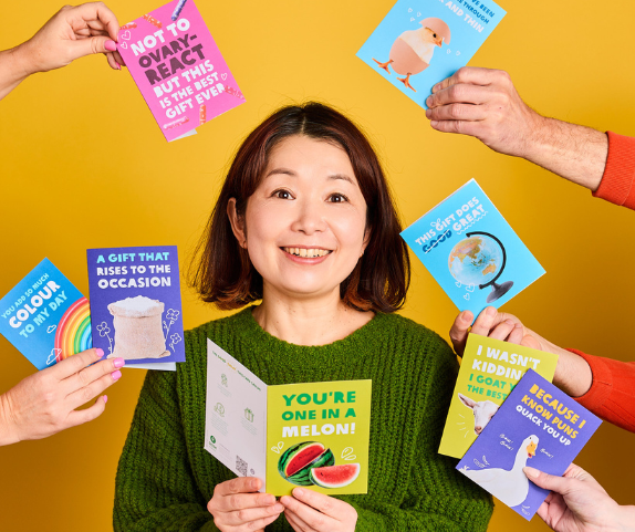 Australia: Mariko holds up an Oxfam Unwrapped Christmas card, with more cards surrounding her. Photo: Michelle Jarni