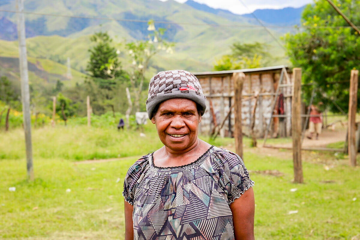 Papua New Guinea: Lavin of Nogorunte community in Papua New Guinea (PNG), is pictured walking past her neighbours as she makes her way to her house and the newly built tap outside of it. Photo: Jeshua Hope/Oxfam