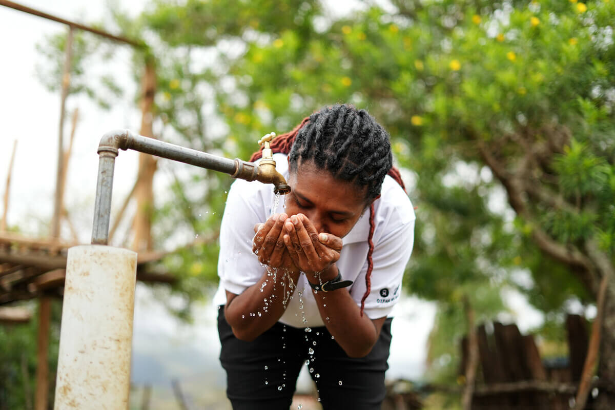 Papua ​New ​Guinea: Maigao Nigo, WASH Program Quality Officer, using a tap recently installed in the hamlet. Prior to the tap installation, the community had to walk hours every day to fetch water. Photo: Aimee Han/Oxfam